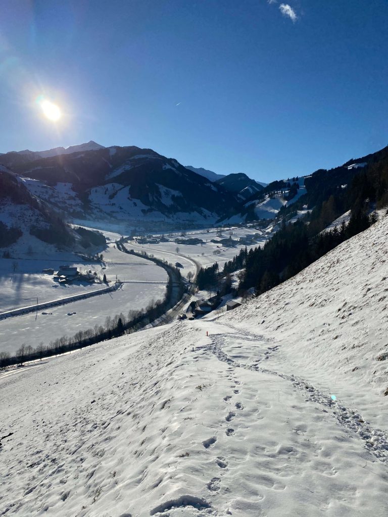 Schneebedeckte Landschaft im Rauriser Tal mit Bergen und klarem Himmel.