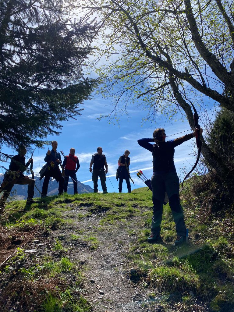 Gruppe beim traditionellen Bogenschießen im Grünen beim Jagdbogenclub Rauris in den Alpen